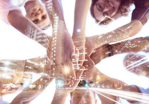 Hands, collaboration and city with digital overlay and business team in a huddle circle for support.